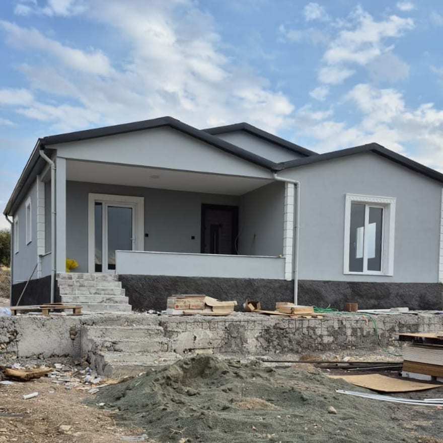 Çift beşik çatılı, gri cepheli prefabrik konut